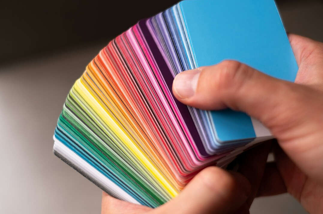 Hand holding a fan of paint color swatches